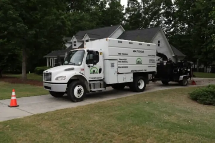AKA Tree Service truck with a wood chipper attachment, cleaning up a yard.